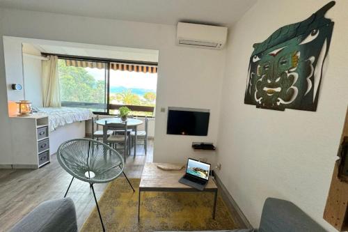 un salon avec une table et une télévision dans l'établissement Charming 37 m nest near the sea, à Ajaccio