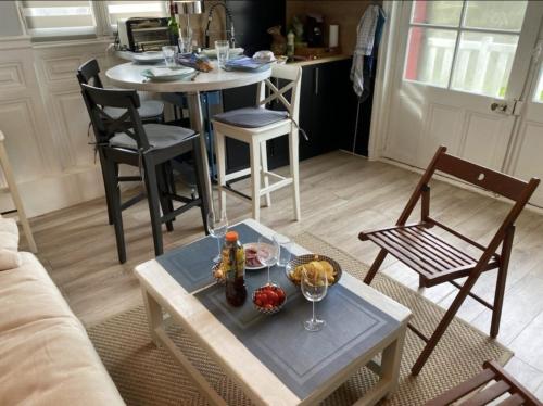un salon avec une table et des chaises et une cuisine dans l'établissement Le Nid Marin 4 personnes accès direct Plage, à Houlgate