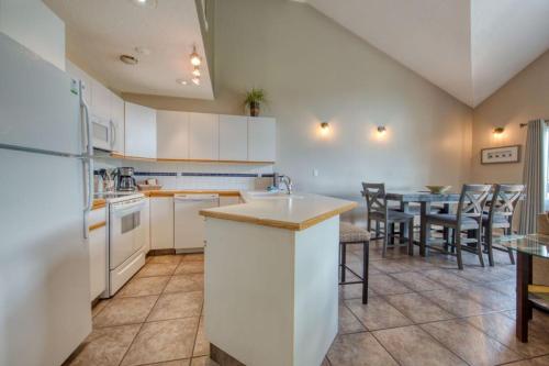 a kitchen with white appliances and a table with chairs at Marble Canyon in Fairmont Hot Springs