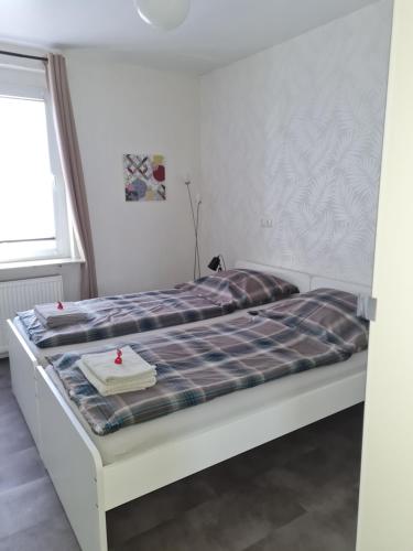 a bedroom with a bed with a plaid mattress at Ferienwohnung in Fuldatal bei Kassel in Fuldatal
