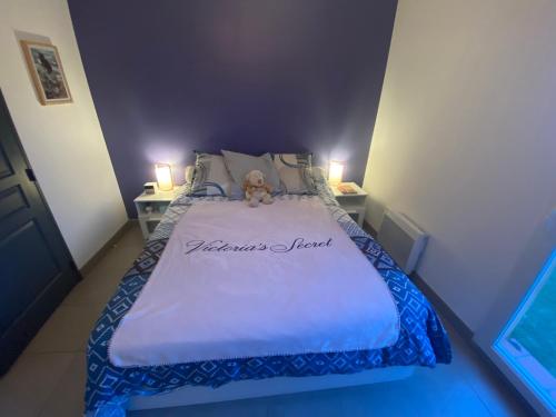 una cama con un osito de peluche sentado encima en Maison avec piscine, climatisée, proche plage, en Roquebrune-sur-Argens