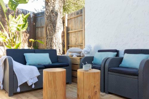 a patio with two couches and two wooden tables at Studio à 200m de la plage de Tahiti beach et à proximité du centre de St Tropez in Saint-Tropez