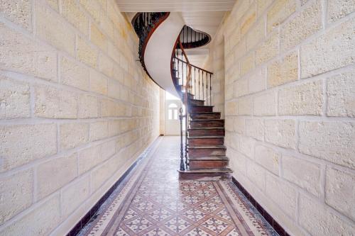 un escalier en colimaçon dans un bâtiment avec un mur en briques dans l'établissement La quiétude de Jonzac, à Saint-Ciers-sur-Gironde