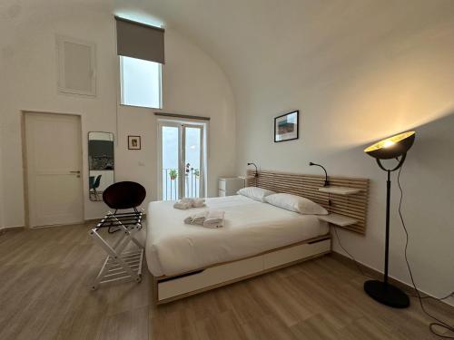 a bedroom with a bed and a lamp and a chair at Casa Garruba 99 in Bari