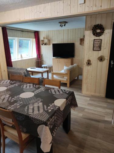 un salon avec une table et un canapé dans l'établissement Les digitales appartement, à Mont-Dore