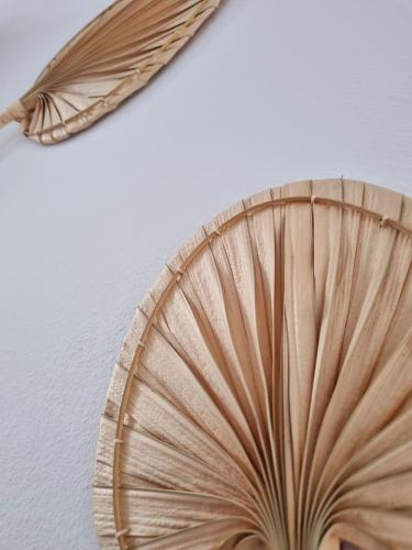 a wooden fan with a feather on a wall at Tolo at sea - Nova in Tolo