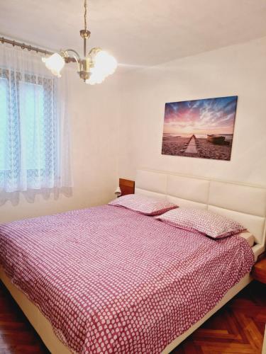 a bedroom with a bed with a red comforter at Apartma Ferjan in Žaga