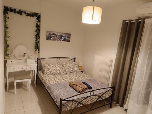 małą sypialnię z łóżkiem i lustrem w obiekcie Demy's apartments w mieście Kardítsa