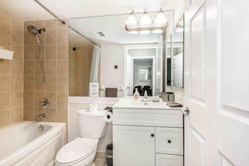 La salle de bains blanche est pourvue de toilettes, d'un lavabo et d'une baignoire. dans l'établissement High-end 2BR/2BA Condo+Views!-Steps from SQ1 Mall, à Mississauga