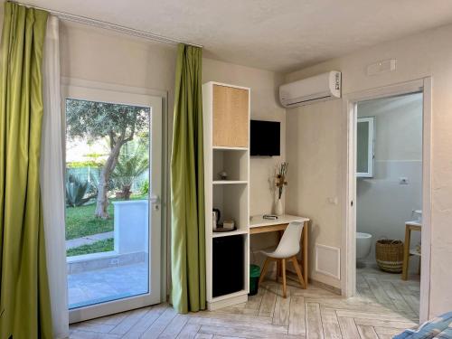 Habitación con escritorio y puerta corredera de cristal. en B&B Kamalei en Tropea
