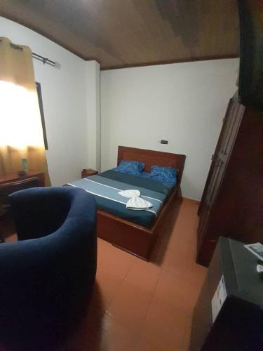 ein kleines Schlafzimmer mit einem Bett und einer Couch in der Unterkunft Coubaahala in Jaunde