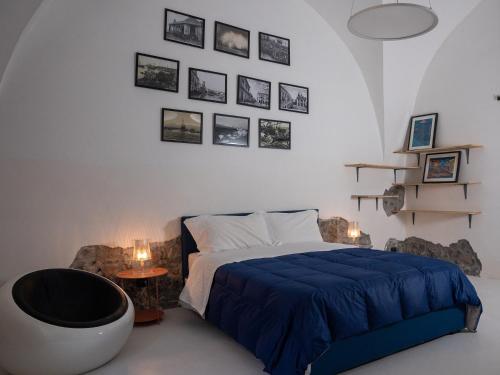 a bedroom with a bed and a chair and pictures on the wall at Pescheria Industriale in Riposto
