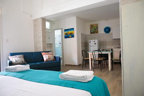 een slaapkamer met een blauwe bank en een keuken bij Casa vacanze Elvy e Uccio 2 in Nardò