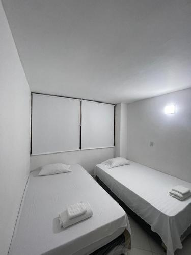 two beds in a room with white walls at Apartamento 202 in Itagüí