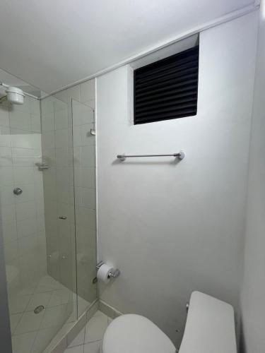a bathroom with a toilet and a glass shower at Apartamento 202 in Itagüí