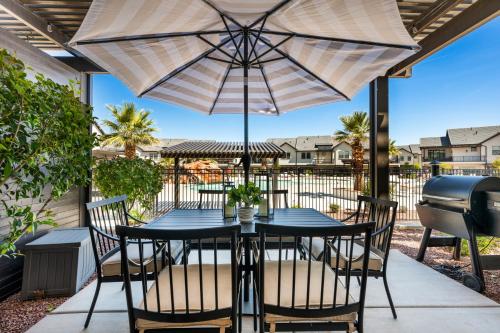patio ze stołem i krzesłami pod parasolem w obiekcie Grand Slam Getaway #5 townhouse w mieście Santa Clara
