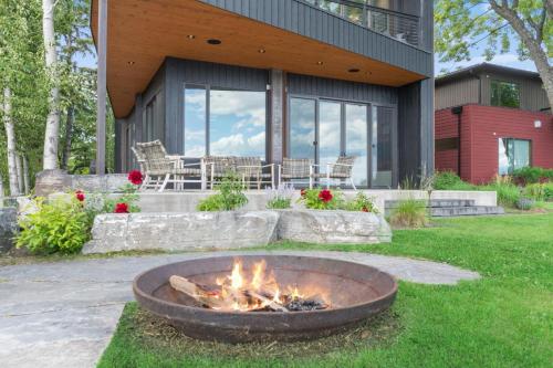 a fire pit in the grass in front of a house at Swan Lake House in Bigfork