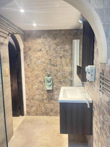 a bathroom with a sink and a stone wall at Stanza Mare Beach Front in Punta Cana