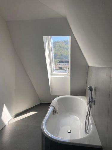 a white bath tub in a room with a window at Das Anton in Gmunden