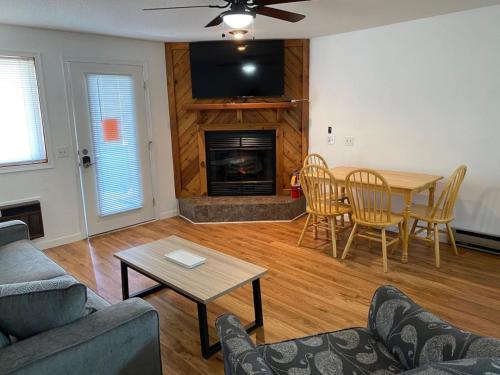 a living room with a couch and a table and a fireplace at Dells Lake Lookout At Lighthouse Cove Condominiums in Wisconsin Dells