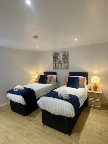 a bedroom with two beds with blue and white sheets at Cozy Cheltenham Accomodation in Cheltenham