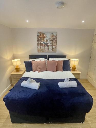 a bedroom with a large blue bed with towels on it at Cozy Cheltenham Accomodation in Cheltenham