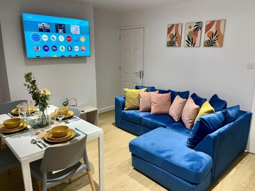 a living room with a blue couch and a table at Cozy Cheltenham Accomodation in Cheltenham