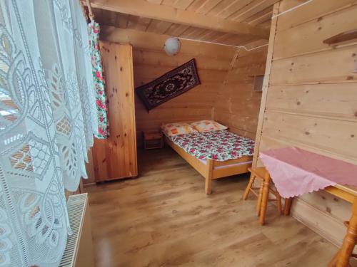 Habitación con cama en una cabaña de madera en Ośrodek Wczasowy U Góralki en Murzasichle
