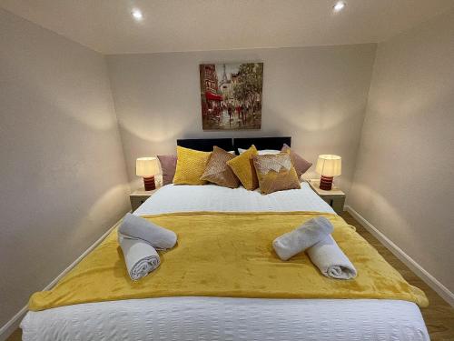 a bedroom with a large bed with yellow sheets and pillows at Cosy House Accommodation in Cheltenham