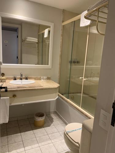uma casa de banho com um lavatório, um chuveiro e um WC. em Ninety Hotel em São Paulo