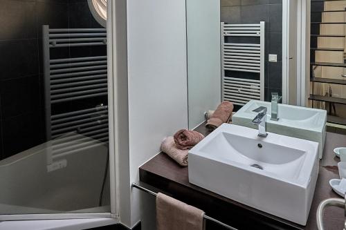 ein Badezimmer mit einem weißen Waschbecken und einer Dusche in der Unterkunft La LUNA of MARSEILLE - VILLA D'ARCHITECTE B&B in Marseille