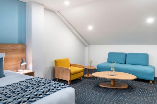 a hotel room with a bed and a couch and a table at Hotel Camino de la Sal in Zipaquirá