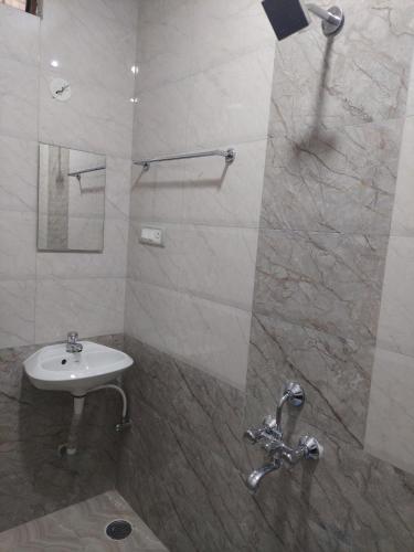 a bathroom with a sink and a shower at Shivaganga Comforts in Bengaluru