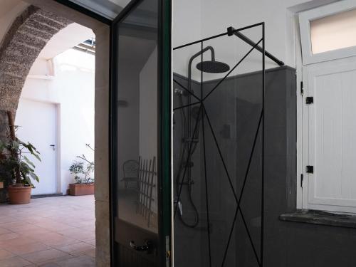 a glass door with a shower in a room at Pescheria Industriale in Riposto
