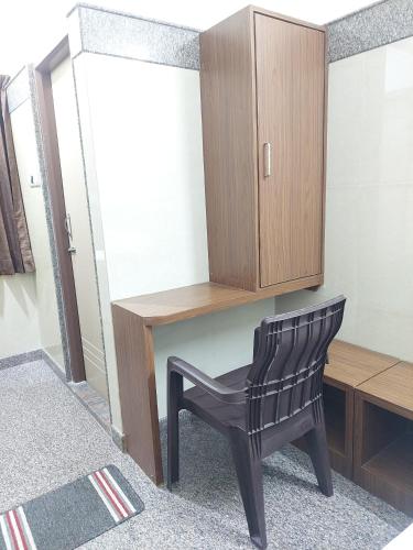a black chair sitting next to a wooden desk at Shivaganga Comforts in Bengaluru