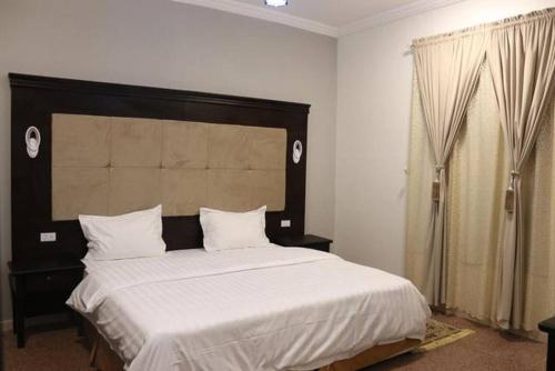 1 dormitorio con 1 cama grande con sábanas blancas en Orgy Guest House, en Amán