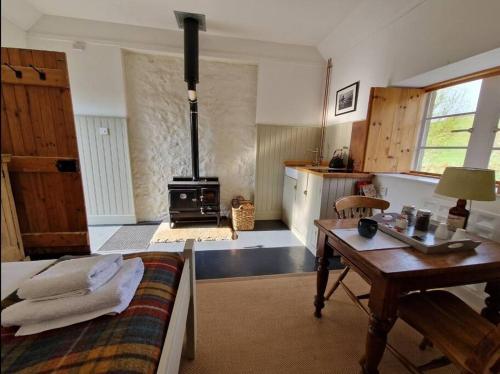 een woonkamer met een bed en een fornuis bij Beatshach Bothy - Speyside, Incredible location! in Dufftown