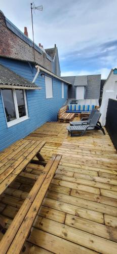 une terrasse en bois avec deux chaises sur une maison dans l'établissement Ault vue mer, à Ault