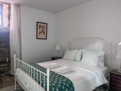 a bedroom with a white bed with white pillows at Imperial Douro Apartamento 3 in Peso da Régua