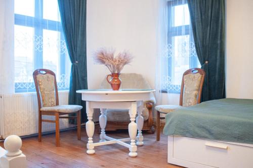 a room with a table and two chairs and a bed at Cazare La Cetate in Moşna