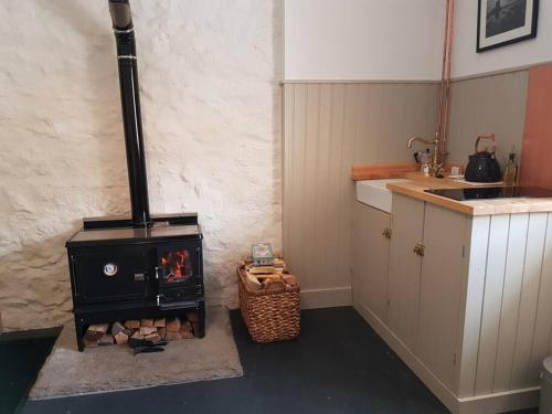 een keuken met een houtkachel in een kamer bij Beatshach Bothy - Speyside, Incredible location! in Dufftown