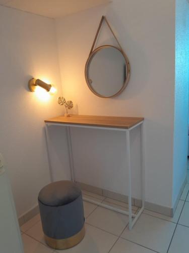 une coiffeuse avec un miroir et un tabouret dans l'établissement Naturistecapdagde L'indigo, au Cap d'Agde