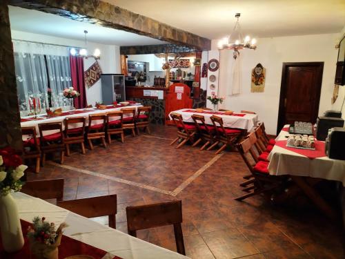 un restaurant avec des tables et des chaises et un réfrigérateur rouge dans l'établissement Vila Rina, à Moieciu de Sus