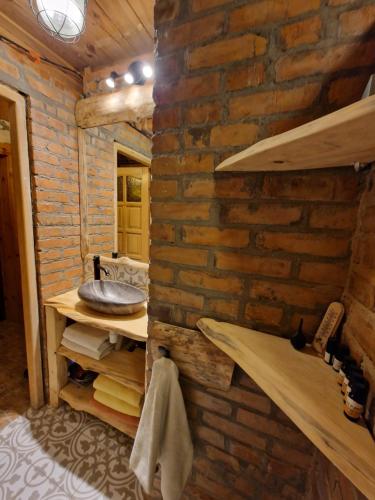 a bathroom with a brick wall and a sink at Harcówka in Miękisz Nowy