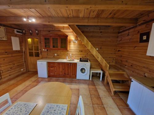 a kitchen in a log cabin with a washing machine at Harcówka in Miękisz Nowy