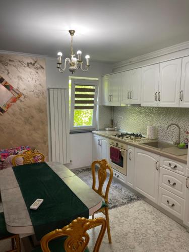 a kitchen with white cabinets and a table and a chandelier at Tamara’s Place in Râmnicu Vâlcea