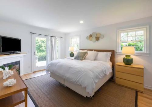 a bedroom with a large bed and a fireplace at Luxurious 3 Bedroom House In Hampton in East Hampton