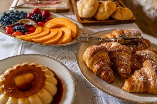 a table with two plates of pastries and fruit at Pietraio in Radicondoli