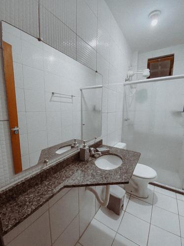 a bathroom with a sink and a toilet at Condomio Coqueiros Residence in Salvador