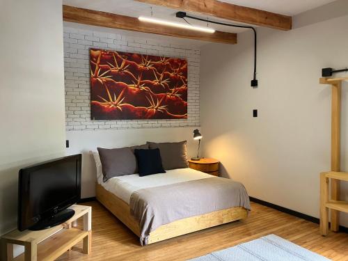a bedroom with a bed and a painting on the wall at Coyoacan historico, museo Frida. in Mexico City